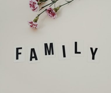 Elegant arrangement of pink flowers and family text on a white background, ideal for family themes.